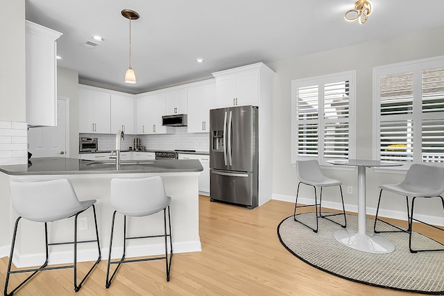 kitchen with white cabinetry, stainless steel appliances, sink, backsplash, and kitchen peninsula