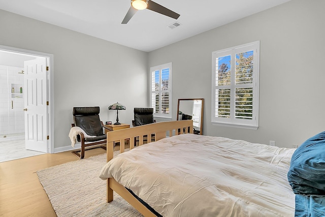 bedroom with ensuite bathroom, ceiling fan, and hardwood / wood-style floors