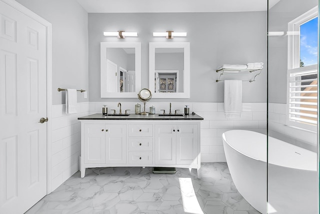 bathroom with vanity, tile walls, and a bathing tub