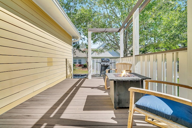 wooden deck featuring grilling area and a fire pit