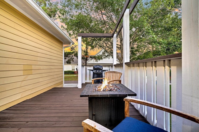 wooden terrace with area for grilling and an outdoor fire pit