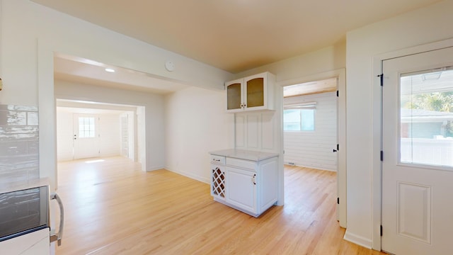 kitchen with a healthy amount of sunlight, light hardwood / wood-style flooring, and white cabinets