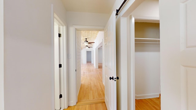 hall with a barn door and hardwood / wood-style floors