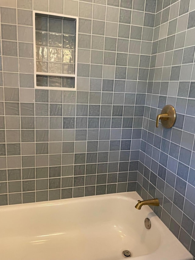 bathroom featuring tiled shower / bath