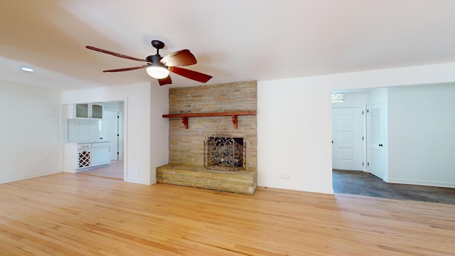 unfurnished living room with ceiling fan, hardwood / wood-style floors, and a fireplace