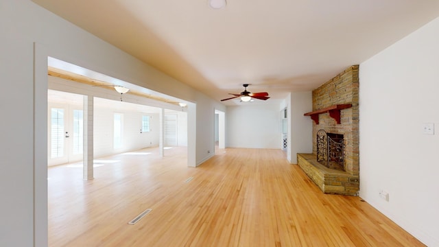 unfurnished living room featuring wood-type flooring, ceiling fan, and a fireplace