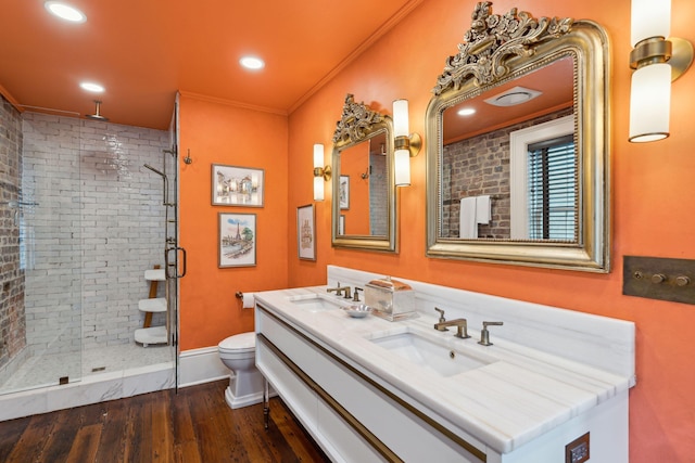 bathroom with a shower with shower door, wood-type flooring, vanity, toilet, and crown molding