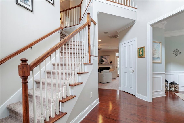 stairway featuring hardwood / wood-style floors and crown molding