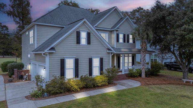 view of front of home with a garage, a yard, and a porch