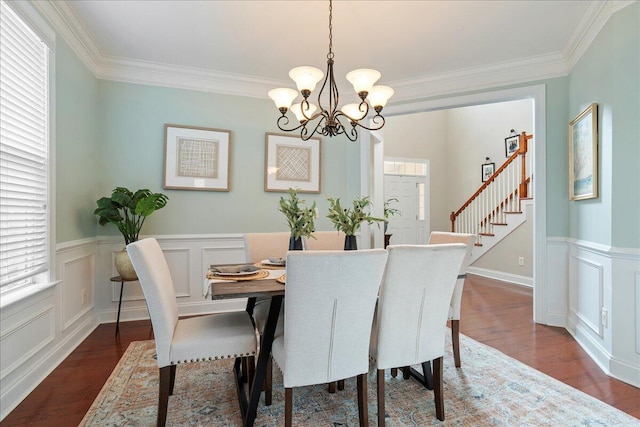 dining area featuring dark hardwood / wood-style floors, crown molding, and an inviting chandelier