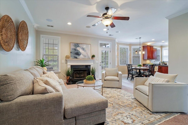 living room featuring crown molding, ceiling fan, and a wealth of natural light