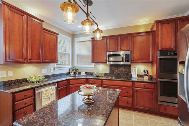 kitchen featuring sink, stainless steel appliances, dark stone counters, and ornamental molding