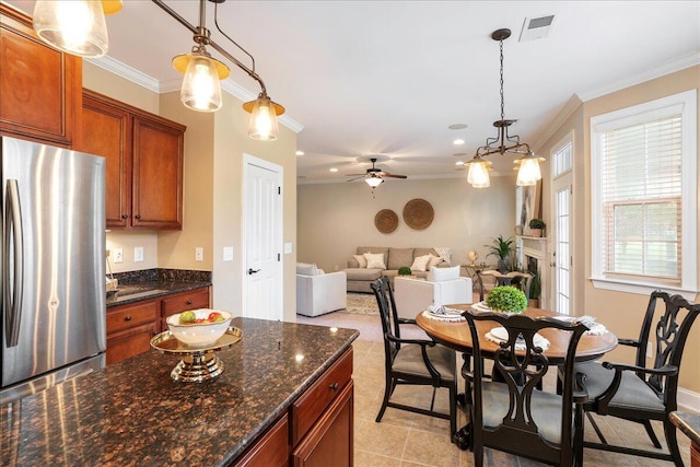 kitchen with pendant lighting, stainless steel fridge, and ornamental molding