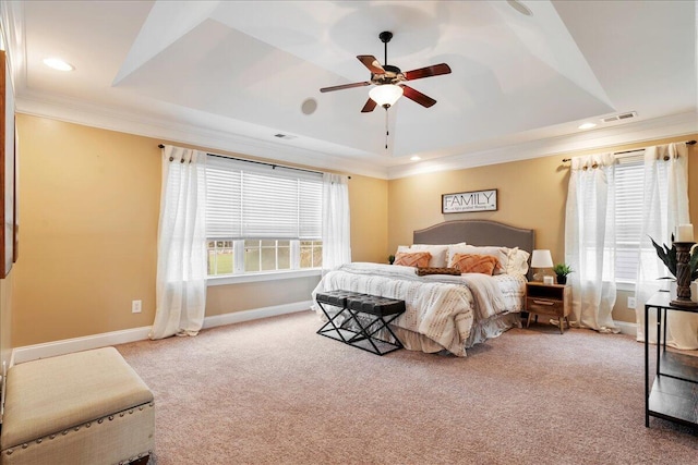 carpeted bedroom with ornamental molding, ceiling fan, and a raised ceiling