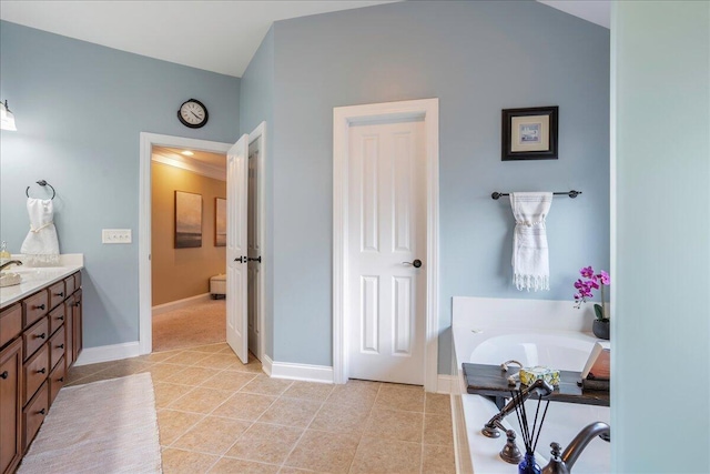 bathroom with vanity, a tub, and tile patterned floors