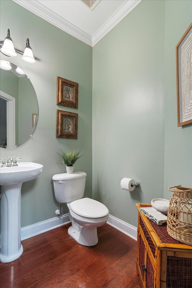 bathroom with sink, hardwood / wood-style floors, toilet, and ornamental molding