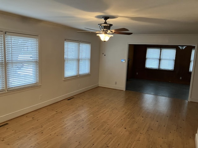 spare room with hardwood / wood-style floors, ceiling fan, ornamental molding, and a wealth of natural light