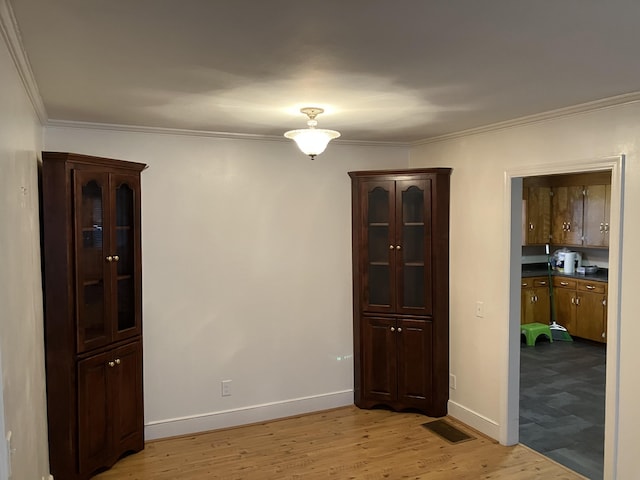 unfurnished room with light hardwood / wood-style flooring and ornamental molding