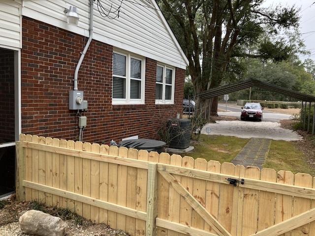 view of side of home with central AC and a carport