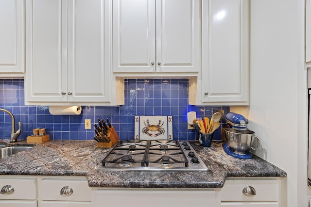 kitchen featuring a sink, tasteful backsplash, white cabinetry, and stainless steel gas stovetop