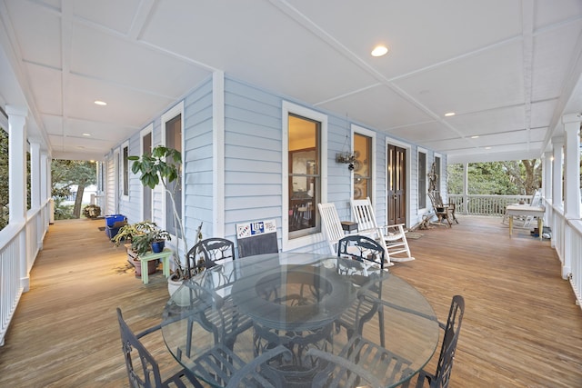 wooden deck featuring a porch and outdoor dining area
