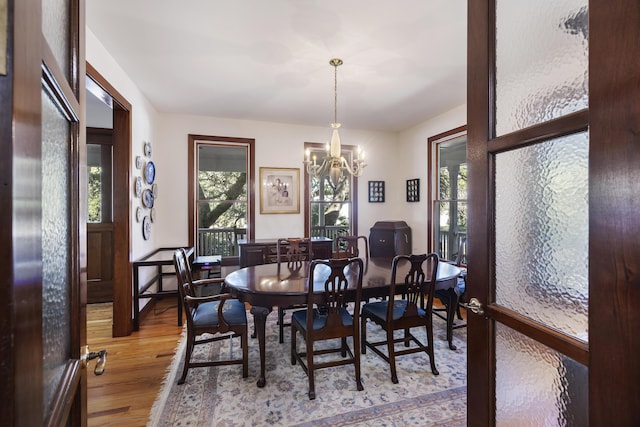 dining room with a wealth of natural light, a notable chandelier, and wood finished floors