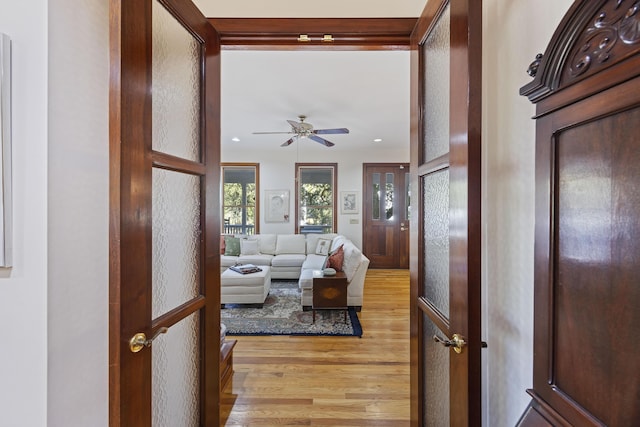 living room featuring light wood-style flooring, a ceiling fan, and recessed lighting