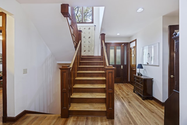 staircase with recessed lighting, baseboards, and wood finished floors