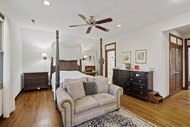 bedroom featuring visible vents, a ceiling fan, recessed lighting, ensuite bath, and wood finished floors