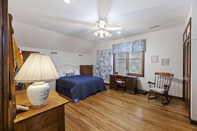 bedroom with a ceiling fan, light wood finished floors, lofted ceiling, and visible vents