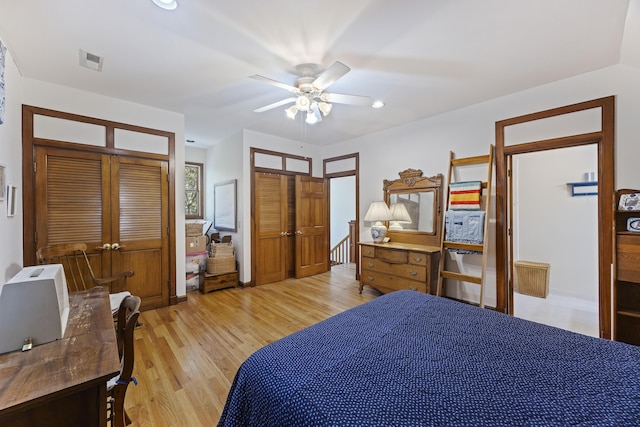 bedroom featuring visible vents, a ceiling fan, multiple closets, recessed lighting, and light wood-style flooring