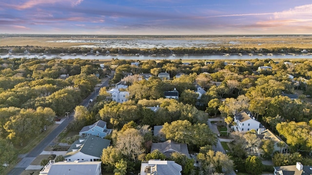 aerial view at dusk featuring a water view