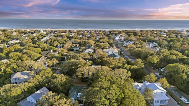 aerial view at dusk featuring a water view