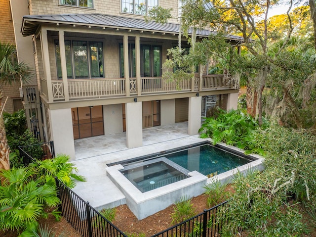 515 Claret Way, Kiawah Island, SC 29455 - rear view of house featuring a standing seam roof, a balcony, stucco siding, metal roof, and a patio area