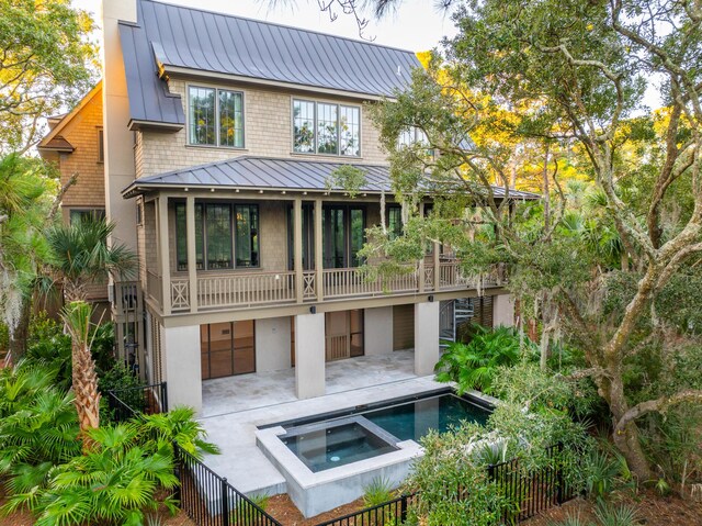 515 Claret Way, Kiawah Island, SC 29455 - rear view of property with a standing seam roof, metal roof, an in-ground hot tub, a balcony, and a patio