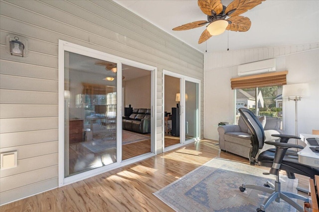 office space featuring light hardwood / wood-style floors, an AC wall unit, and ceiling fan