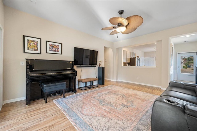 living room featuring ceiling fan and light hardwood / wood-style floors