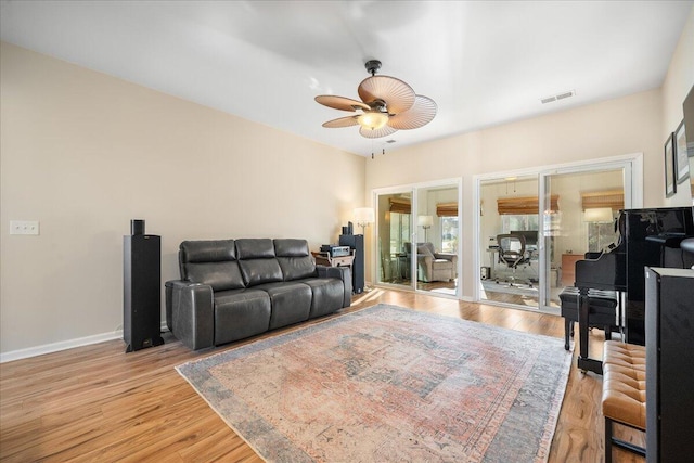 living room with ceiling fan and light hardwood / wood-style flooring