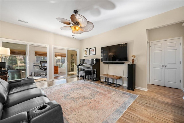 living room with ceiling fan and light hardwood / wood-style floors