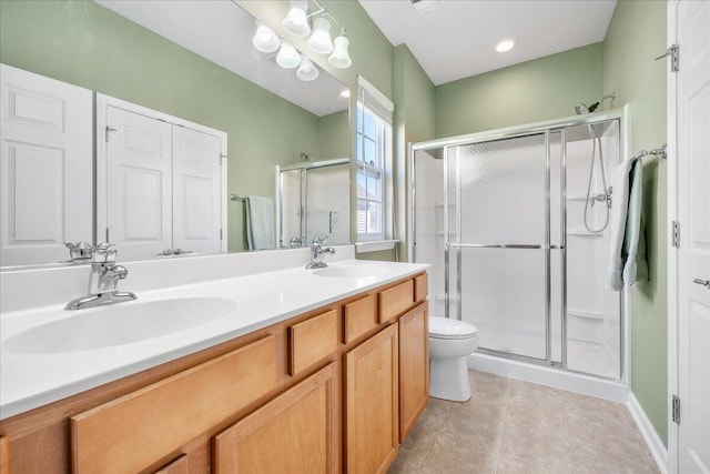 bathroom featuring vanity, a shower with shower door, and toilet