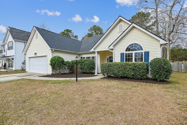 view of property featuring a garage and a front lawn