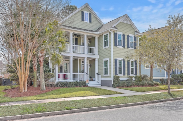 view of front of property featuring a porch, a balcony, a ceiling fan, roof with shingles, and a front yard