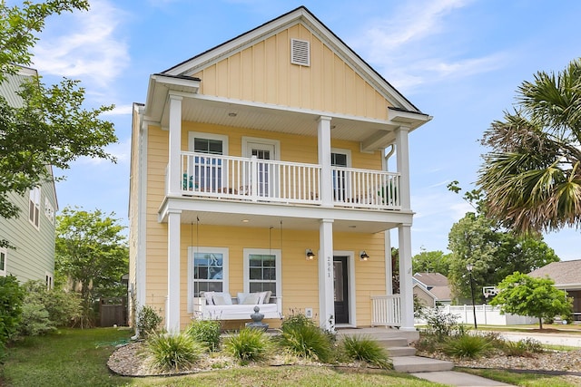 2961 Waterleaf Rd, Johns Island, SC 29455 - view of front of home with a balcony, covered porch, board and batten siding, and a front yard