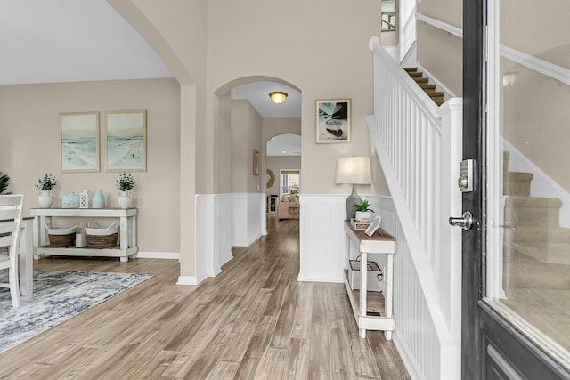 2961 Waterleaf Rd, Johns Island, SC 29455 - foyer entrance featuring arched walkways, stairs, light wood-style floors, and a wainscoted wall