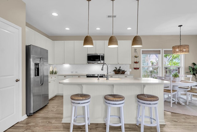 2961 Waterleaf Rd, Johns Island, SC 29455 - kitchen with stainless steel appliances, light countertops, decorative backsplash, light wood-type flooring, and recessed lighting