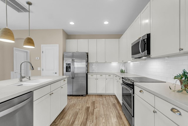 2961 Waterleaf Rd, Johns Island, SC 29455 - kitchen with stainless steel appliances, a sink, light countertops, light wood-type flooring, and white cabinetry