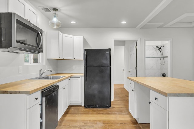 kitchen with decorative light fixtures, sink, white cabinetry, and black appliances