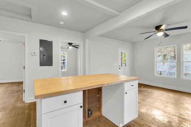 kitchen with white cabinets, wooden counters, light hardwood / wood-style flooring, and electric panel