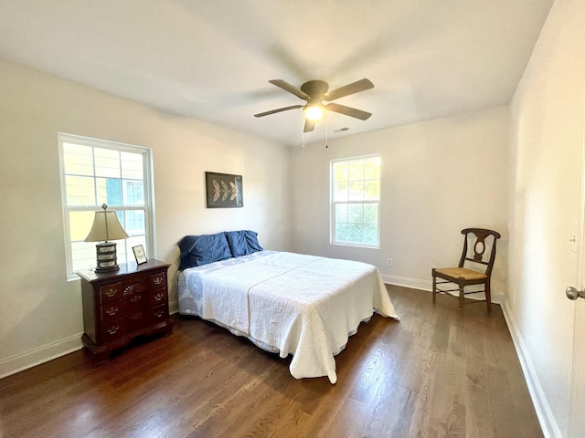 bedroom with dark wood-type flooring, ceiling fan, and multiple windows