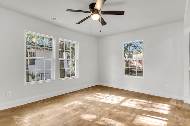 spare room featuring ceiling fan, plenty of natural light, and hardwood / wood-style floors